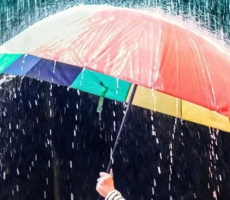 colourful umbrella protecting child from the rain